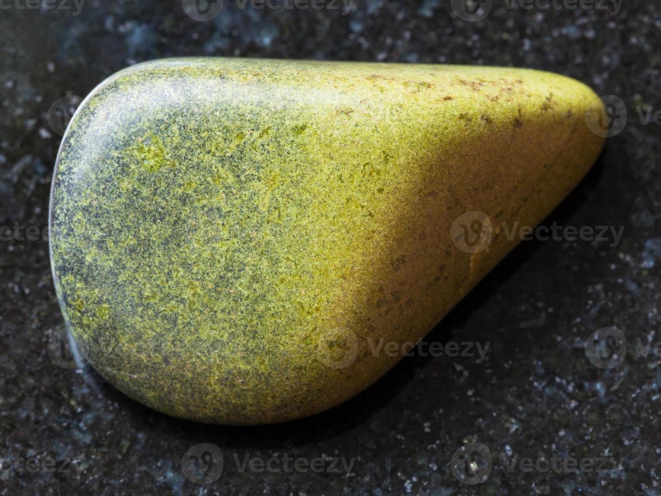 polished epidote gemstone on dark background photo