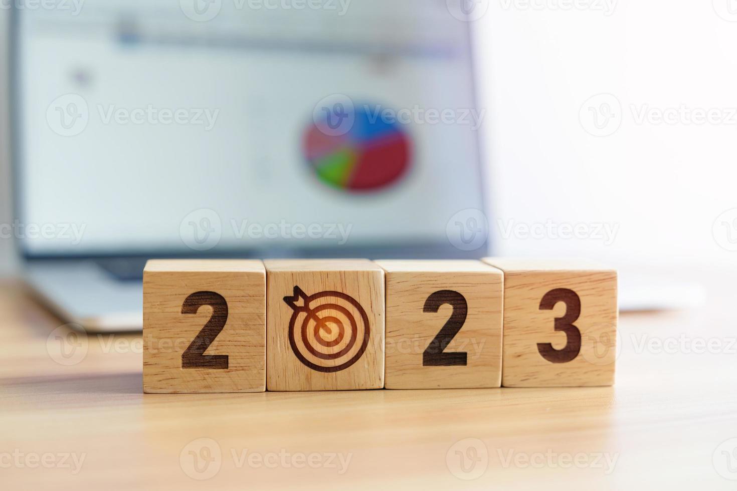 2023 Year block with dartboard icon against computer laptop background. Goal, Target, Resolution, strategy, plan, Action, mission, motivation, and New Year start concepts photo
