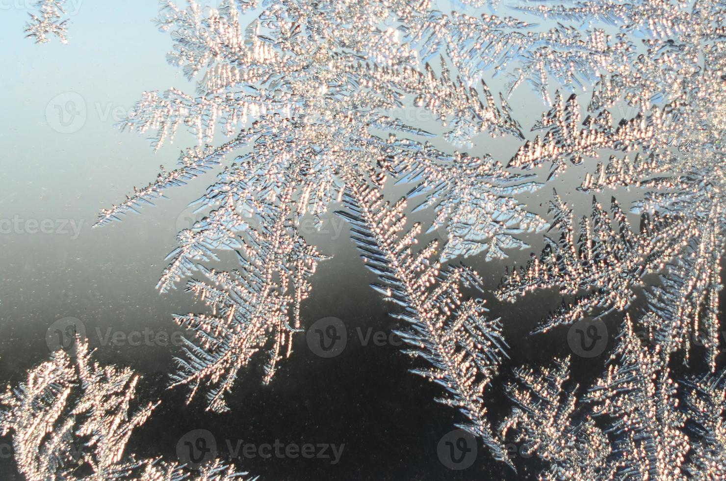 Snowflakes frost rime macro on window glass pane photo