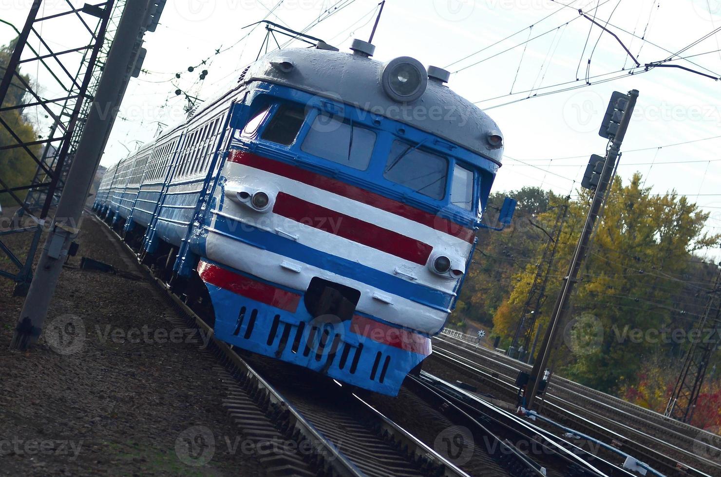 Old soviet electric train with outdated design moving by rail photo