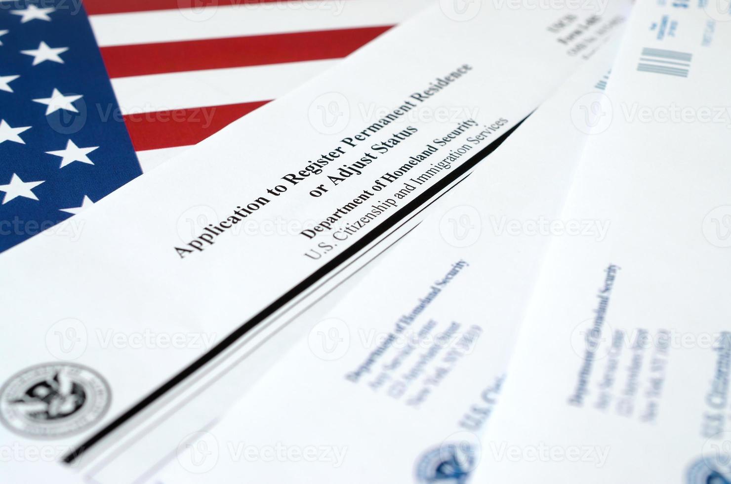La solicitud i-485 para registrar la residencia permanente o ajustar el formulario en blanco de estado se encuentra en la bandera de los Estados Unidos con un sobre del departamento de seguridad nacional foto