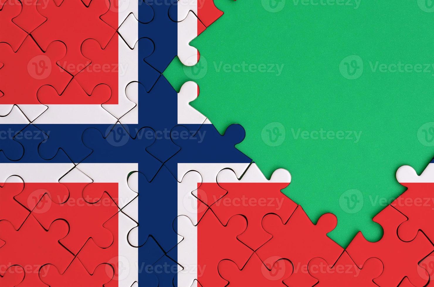 Norway flag is depicted on a completed jigsaw puzzle with free green copy space on the right side photo