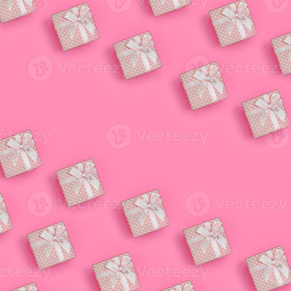 un montón de cajas de regalo rosas se encuentran en el fondo de textura de papel de color rosa pastel de moda en un concepto mínimo. patrón abstracto de moda foto