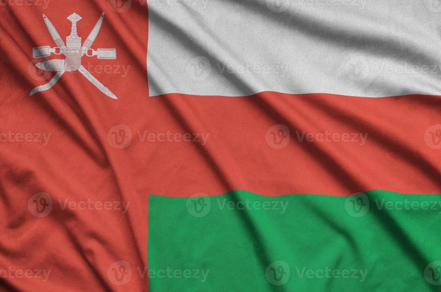 Oman flag is depicted on a sports cloth fabric with many folds. Sport team banner photo