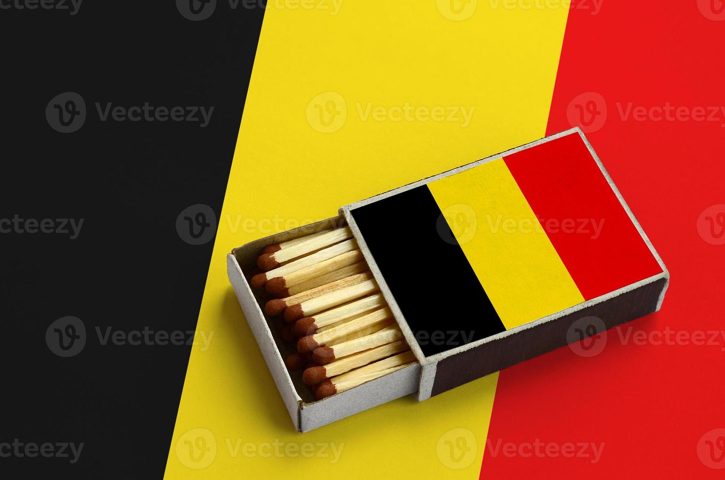 Belgium flag is shown in an open matchbox, which is filled with matches and lies on a large flag photo
