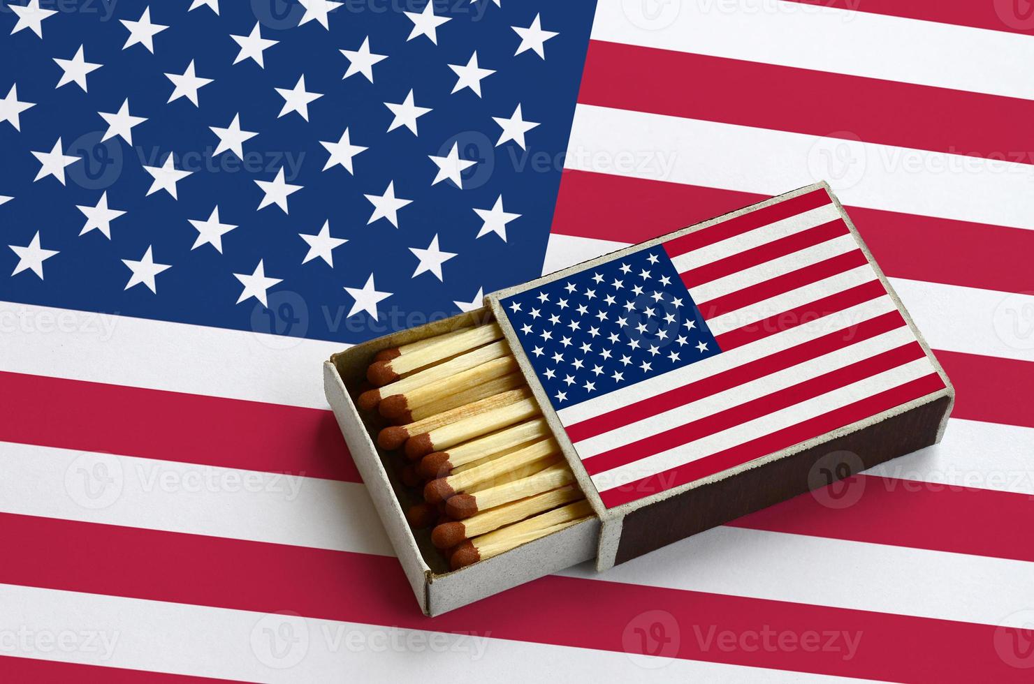 la bandera de los estados unidos de américa se muestra en una caja de fósforos abierta, que está llena de fósforos y se encuentra en una bandera grande foto