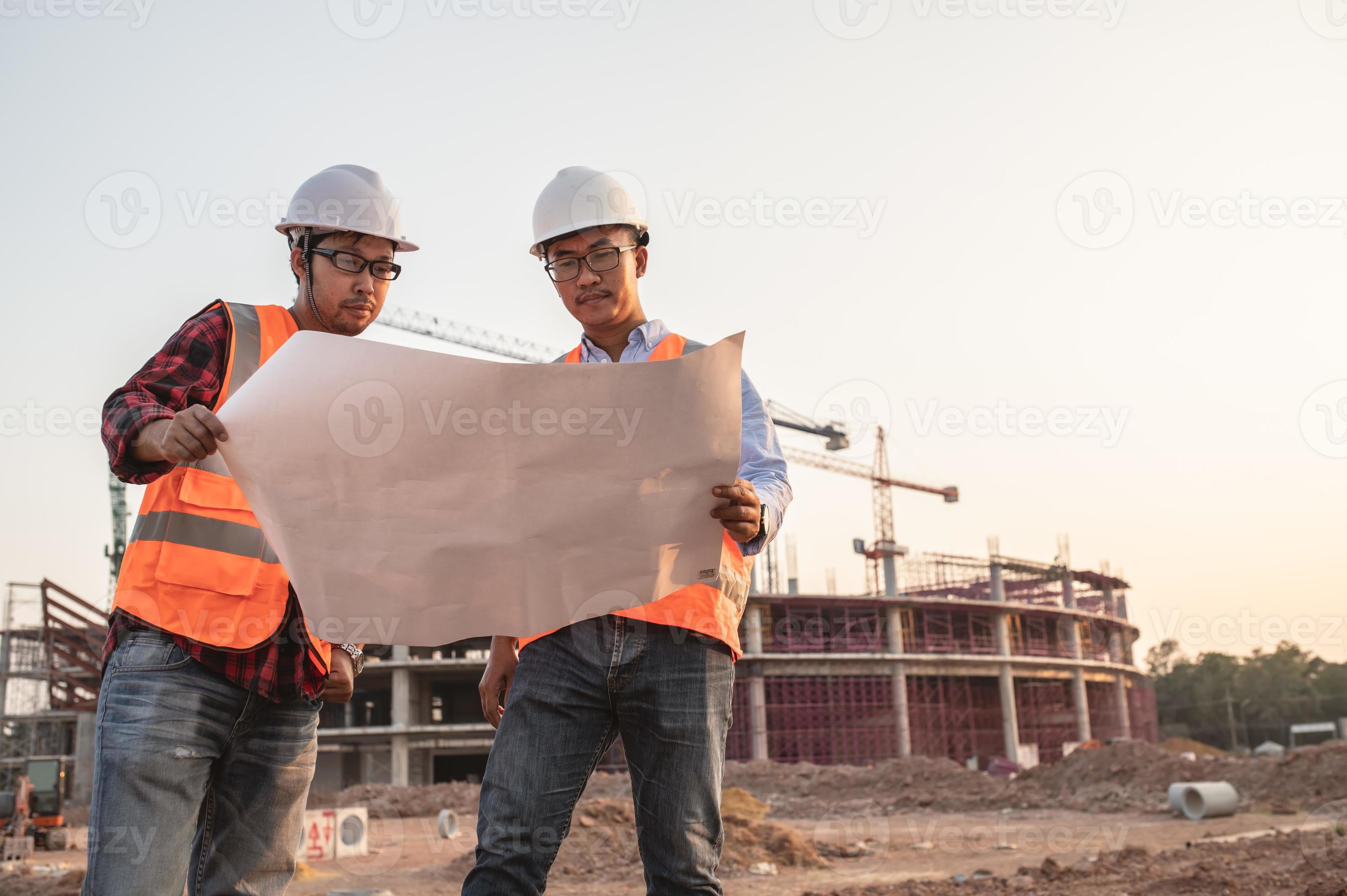 Two Asian engineer working at site of a large building project,Thailand