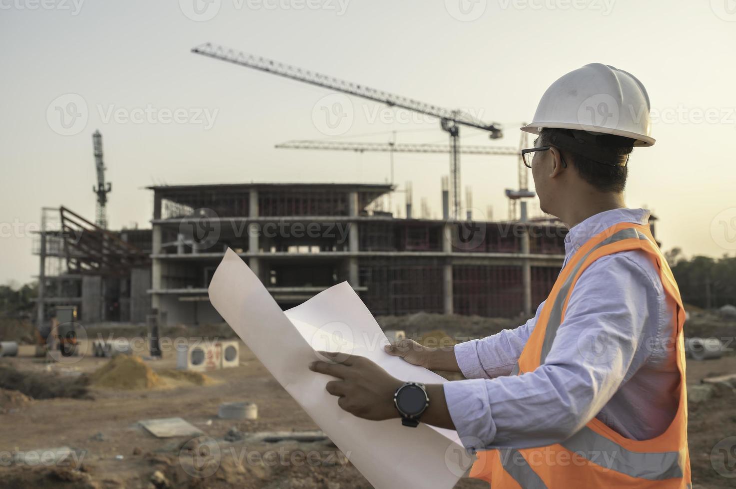 ingeniero asiático que trabaja en el sitio de un gran proyecto de construcción, gente de tailandia, trabaja horas extra en el sitio de construcción foto