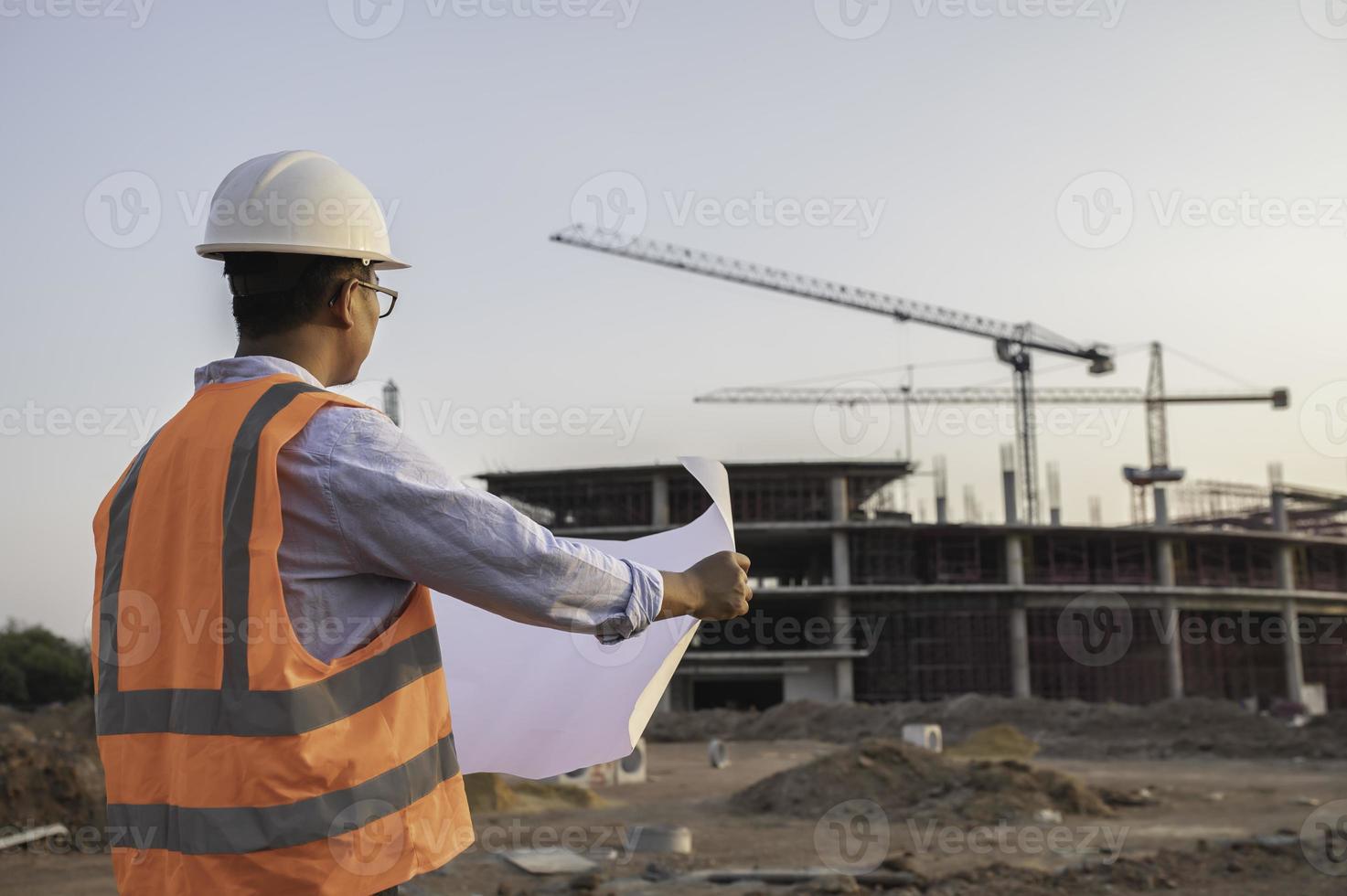 Asian engineer working at site of a large building project,Thailand people,Work overtime at construction site photo