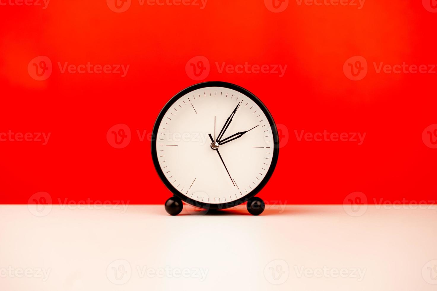 white alarm clock isolated on red background photo