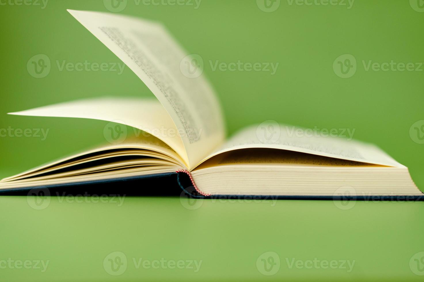 open book on green background reading concept photo