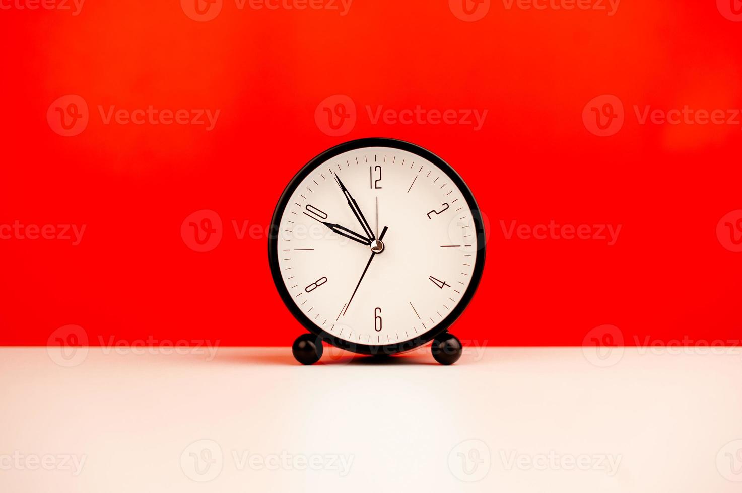 white alarm clock isolated on red background photo