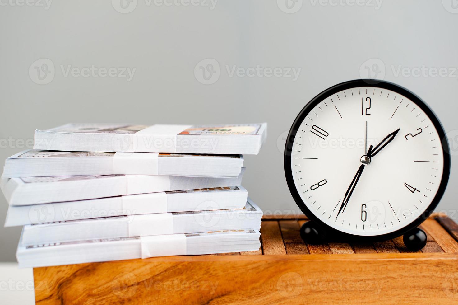 reloj de alarma blanco puesto en dólar de plata y concepto de finanzas simplificado en el tiempo foto