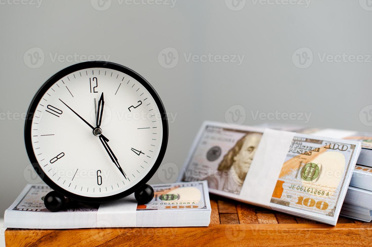 white alarm clock put on silver dollar and time streamlined finance concept photo