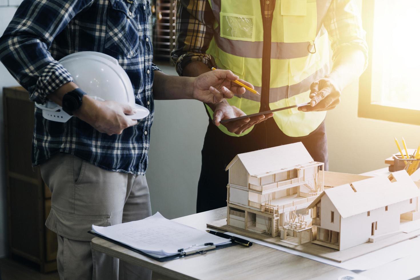 ingeniero de construcción que trabaja en planos para construir grandes edificios comerciales en la oficina. herramientas de ingeniería y concepto de construcción. foto