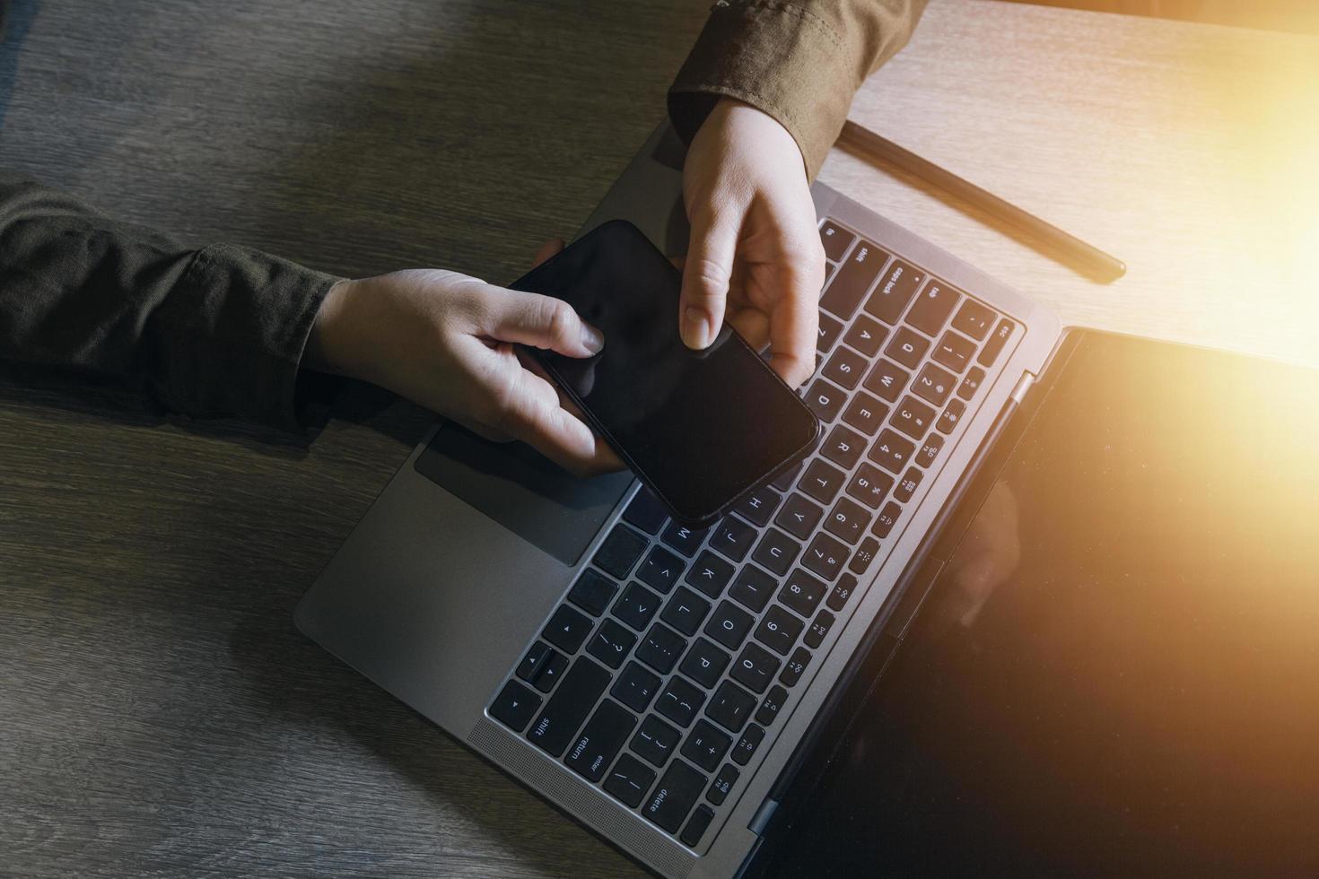 businesswoman hand working with laptop computer, tablet and smart phone in modern office with virtual icon diagram at modernoffice in morning light photo