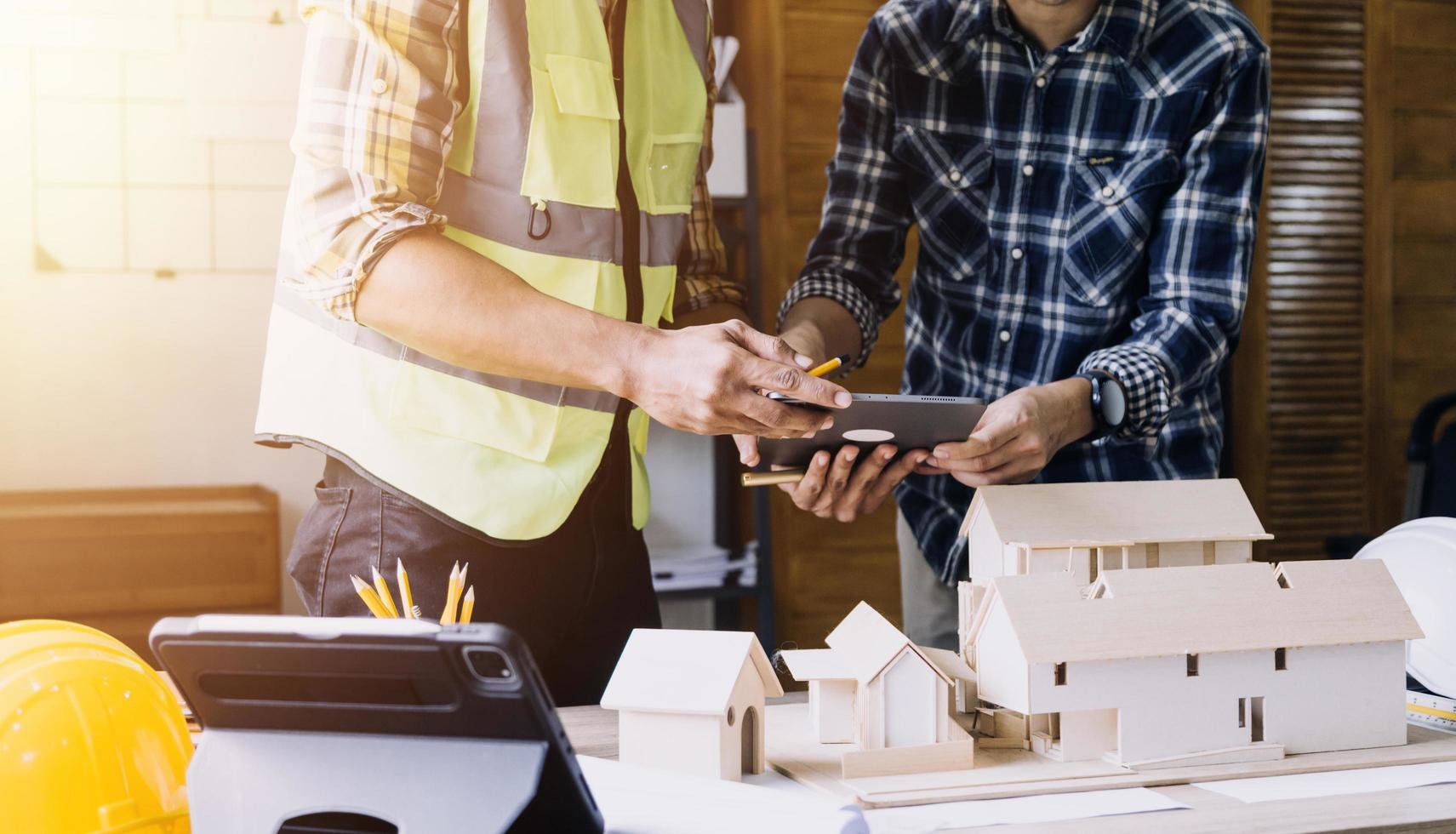 ingeniero de construcción que trabaja en planos para construir grandes edificios comerciales en la oficina. herramientas de ingeniería y concepto de construcción. foto