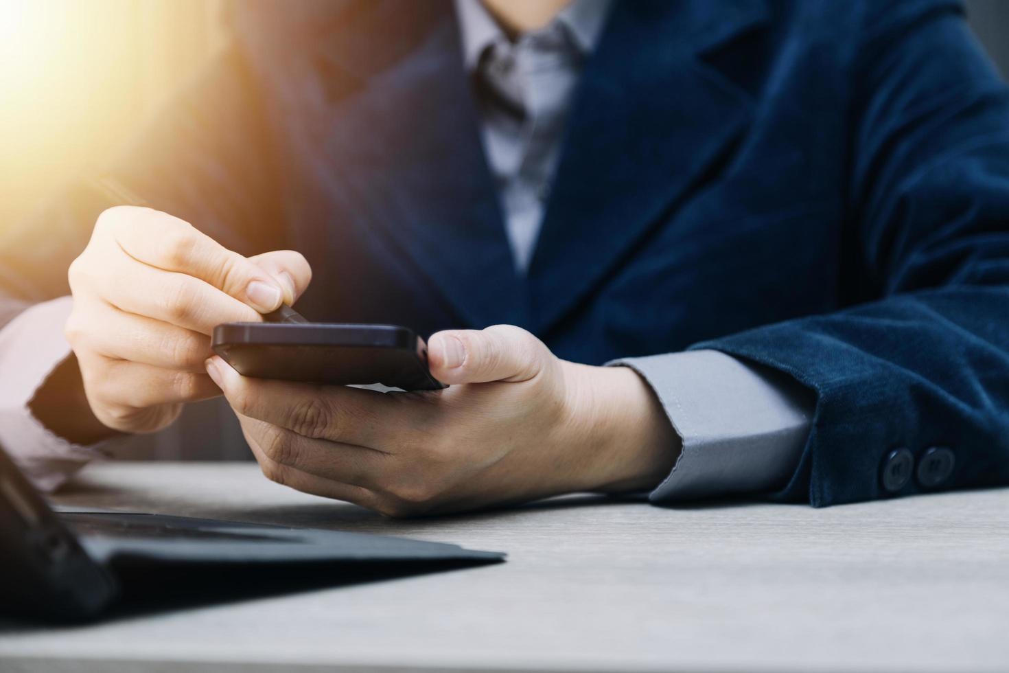 mano de mujer de negocios trabajando con computadora portátil, tableta y teléfono inteligente en la oficina moderna con diagrama de icono virtual en la oficina moderna a la luz de la mañana foto