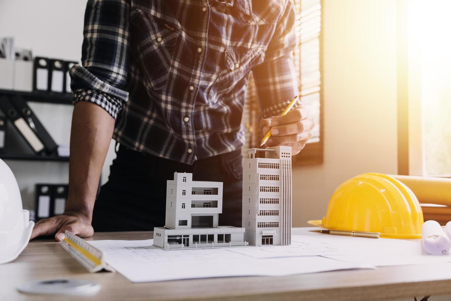 Construction engineer working at blueprint to build large commercial buildings in office. Engineering tools and construction concept. photo