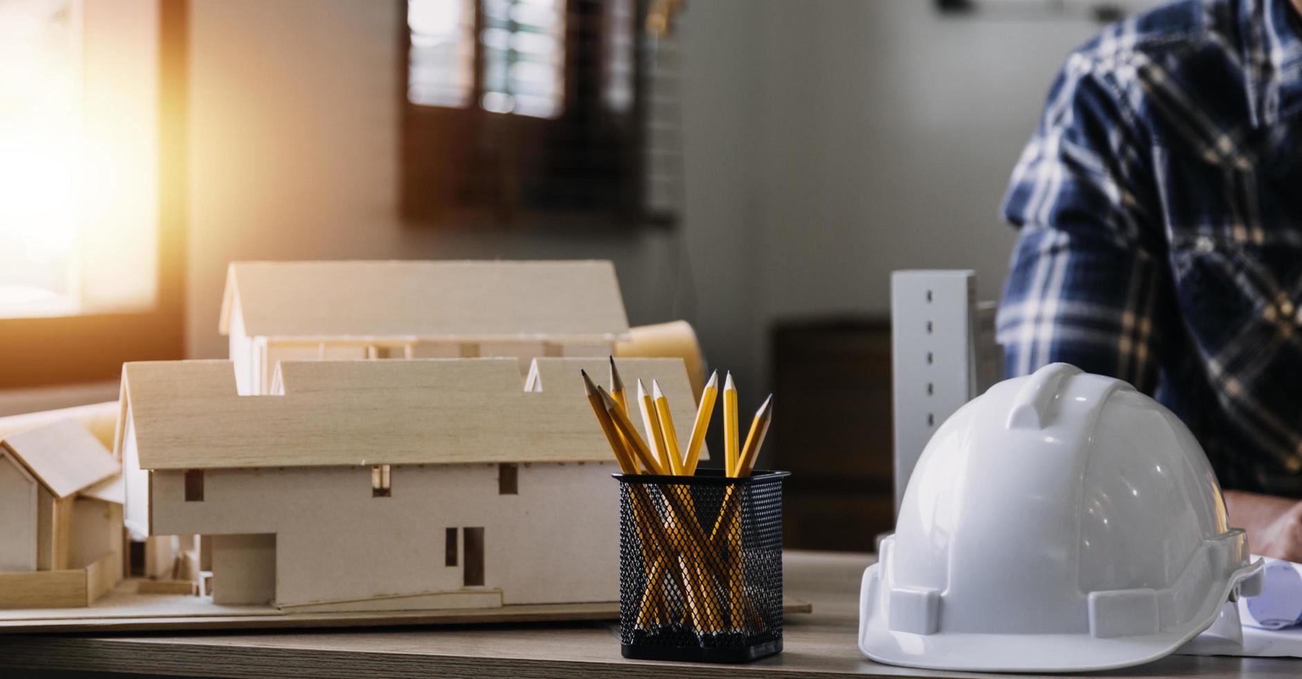 Construction engineer working at blueprint to build large commercial buildings in office. Engineering tools and construction concept. photo