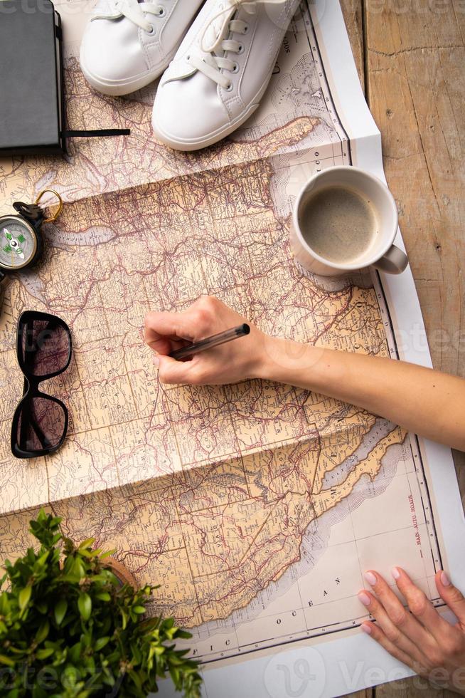 woman hand drawing on travel map, planning trip or vacation photo