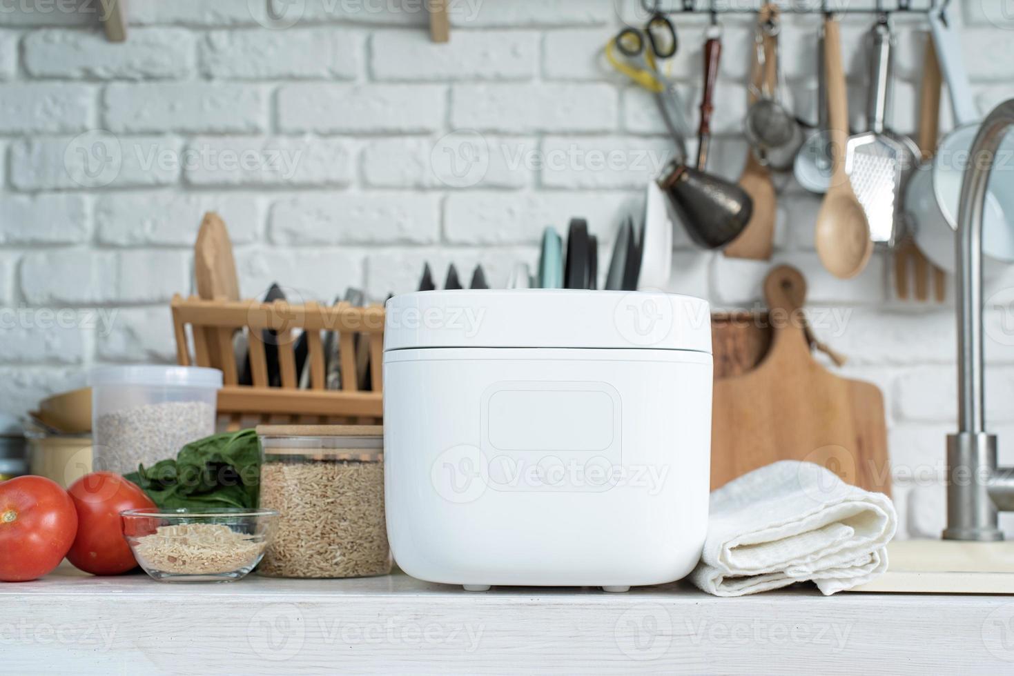 Electric rice cooker on wooden counter-top in the kitchen photo