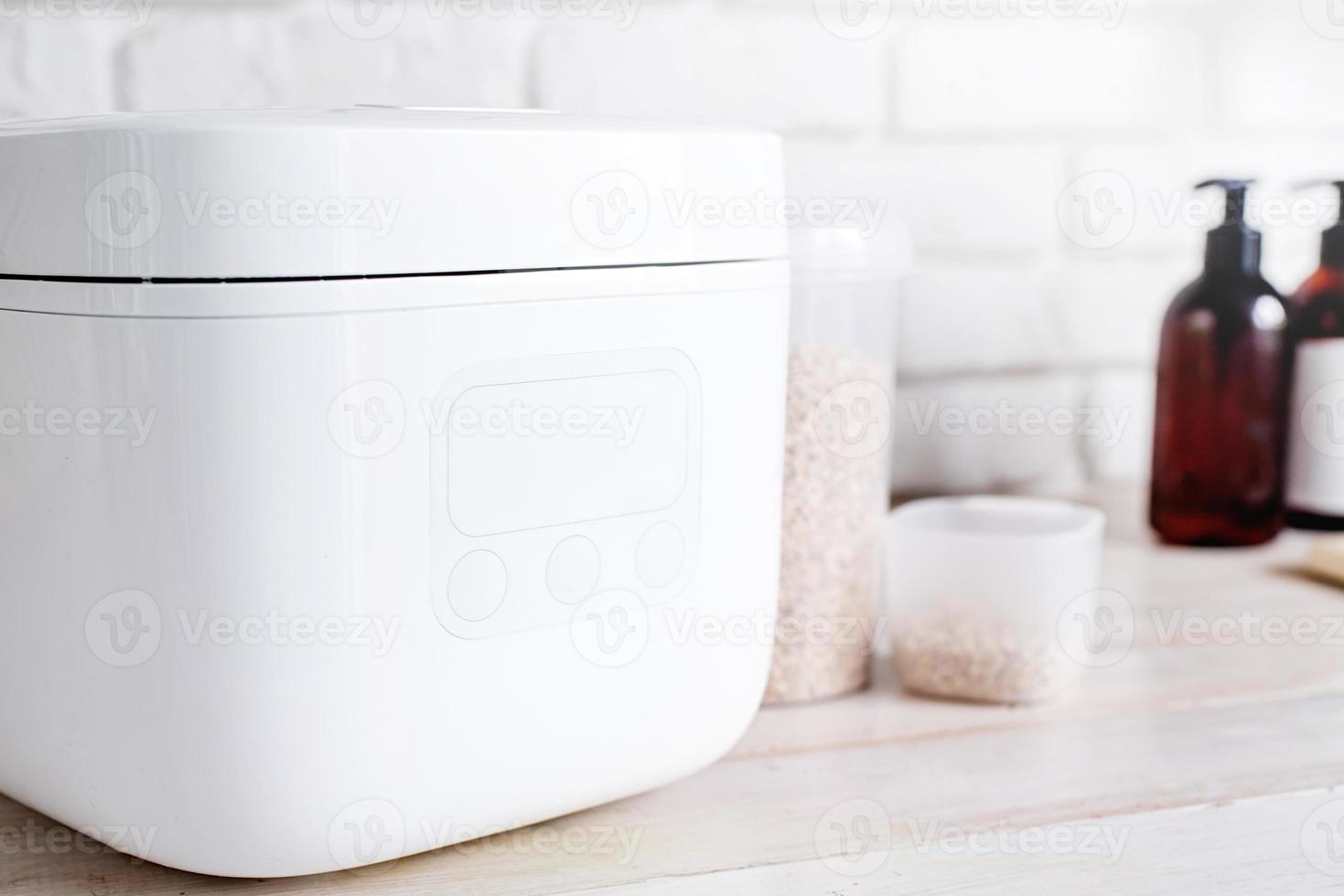 Electric rice cooker on wooden counter-top in the kitchen, closeup of display photo