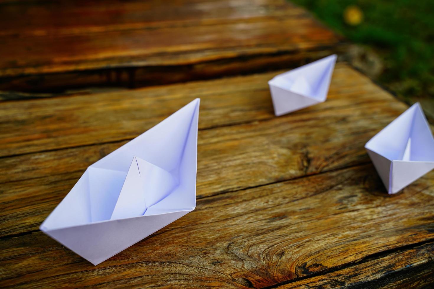 Origami, white paper boat isolated on a wooden floor.  Paper boats mean walking.  feeling of freedom  leadership photo