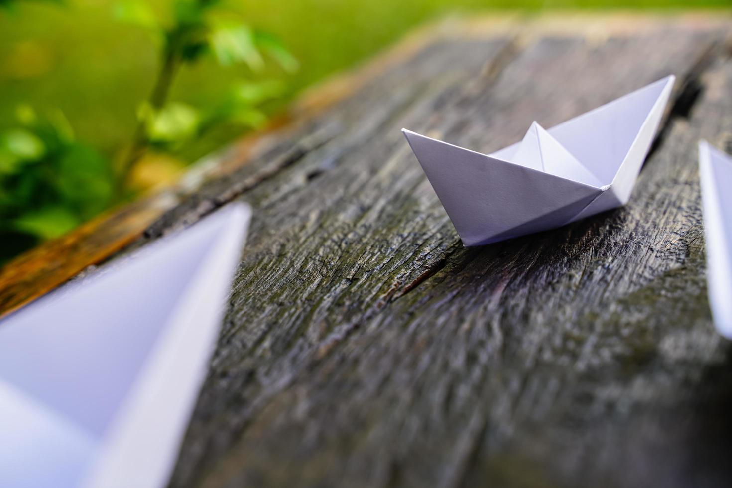 origami, barco de papel blanco aislado en un piso de madera. Los barcos de papel significan caminar. sentimiento de libertad liderazgo foto