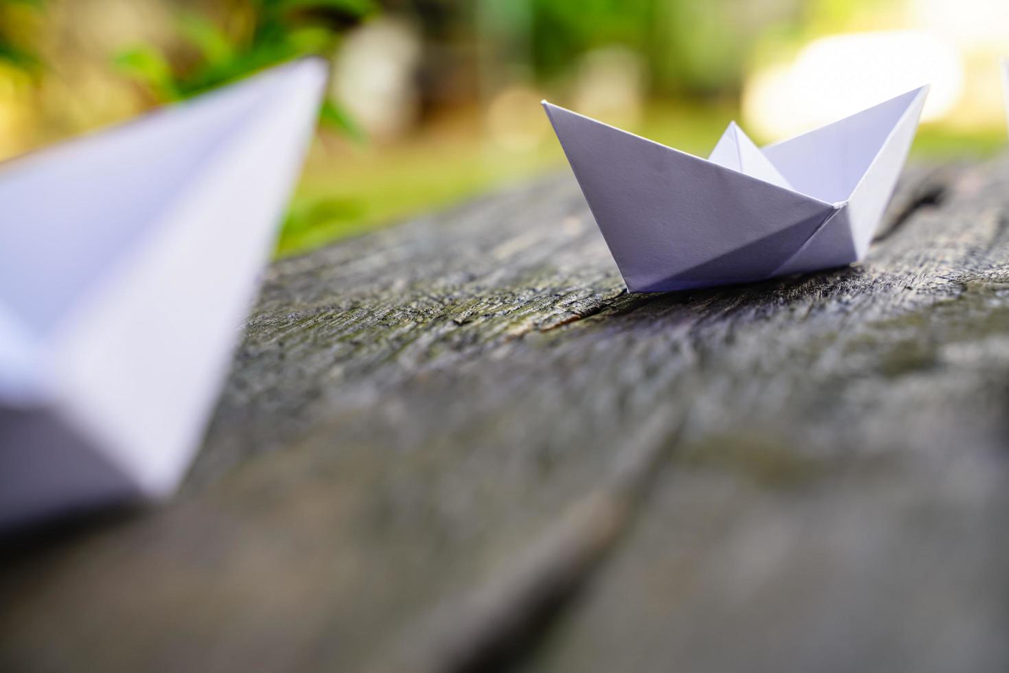 origami, barco de papel blanco aislado en un piso de madera. Los barcos de papel significan caminar. sentimiento de libertad liderazgo foto