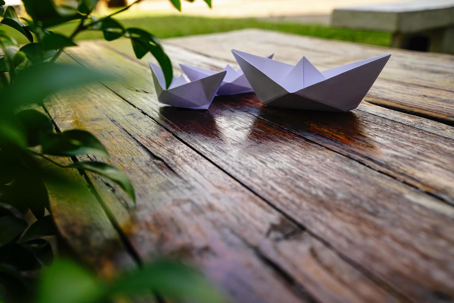 origami, barco de papel blanco aislado en un piso de madera. Los barcos de papel significan caminar. sentimiento de libertad liderazgo foto