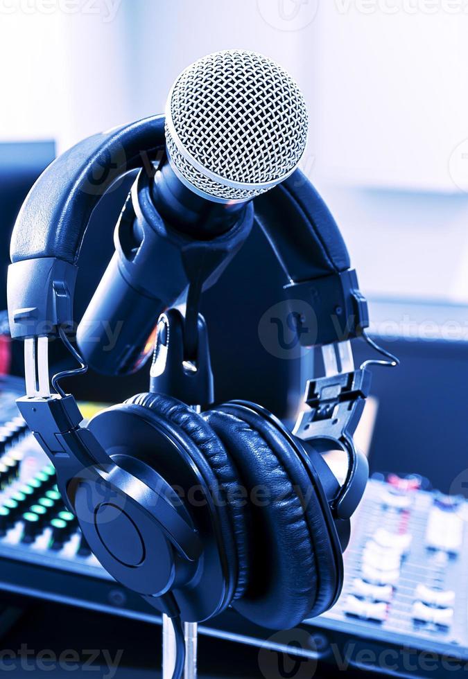 Microphone and headphone on tripod and headphone with mixer background