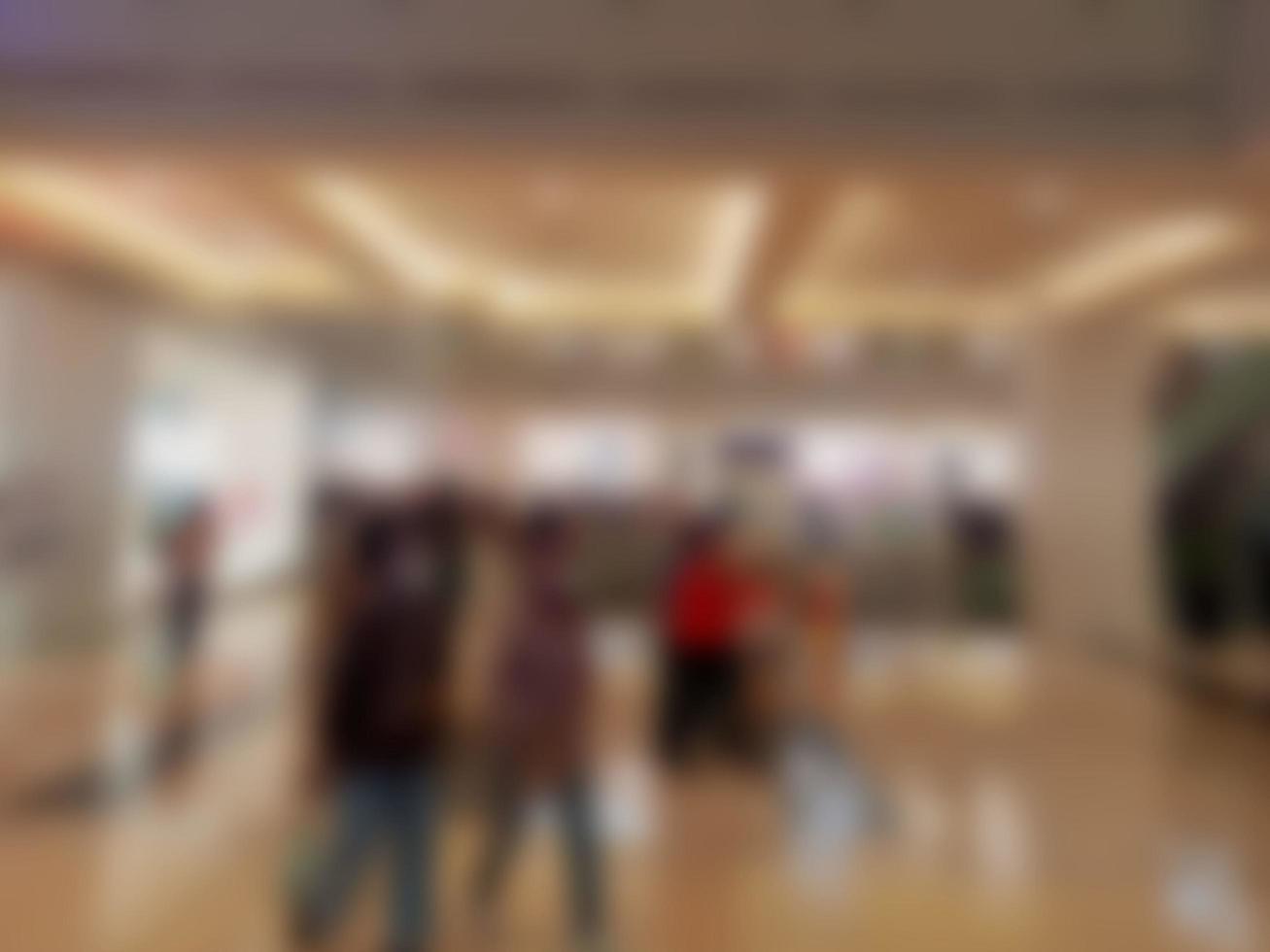 Defocused abstract background of in front of a mall with a lot of people shopping in the background photo