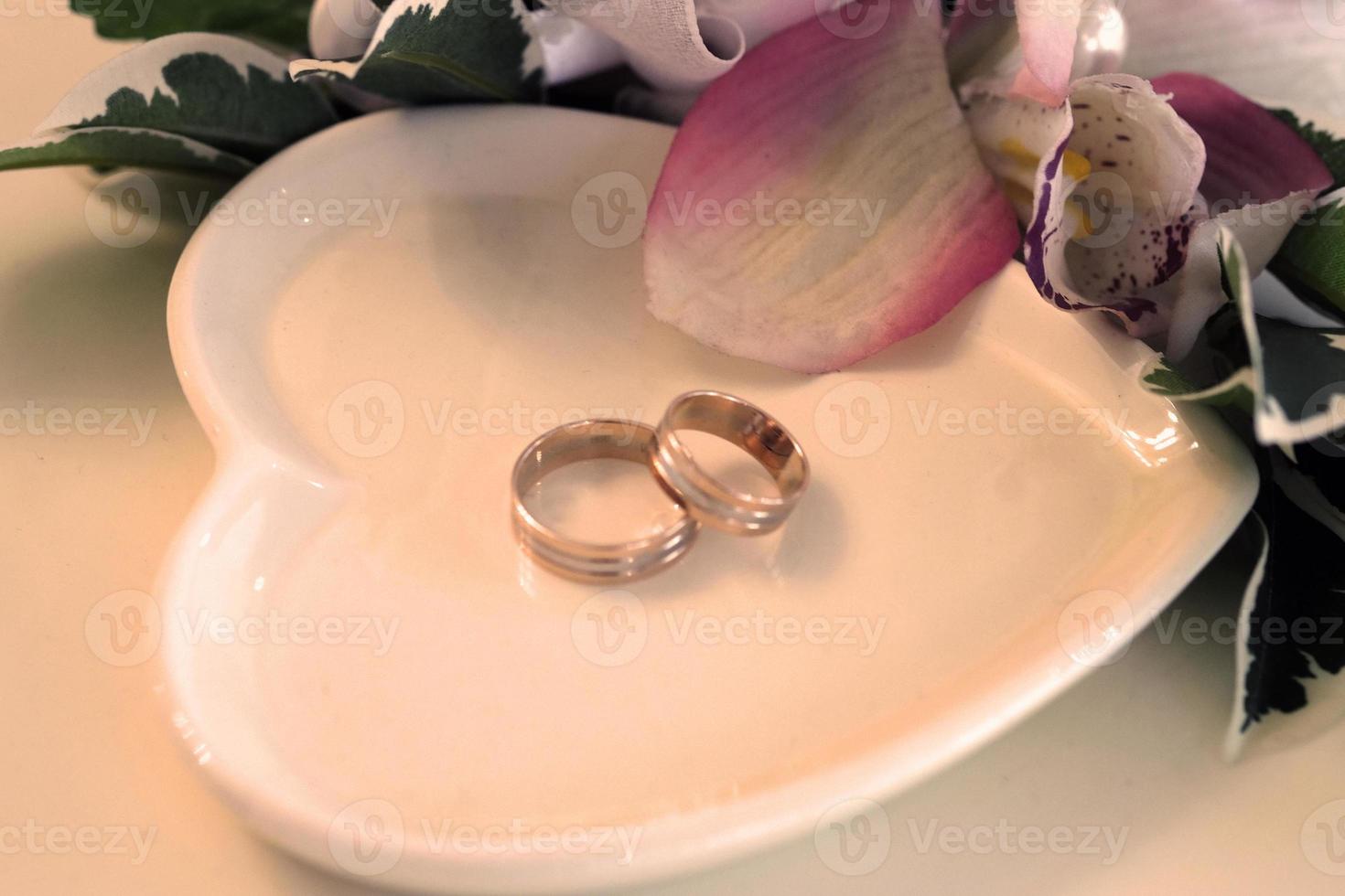 Wedding rings on a white saucer photo