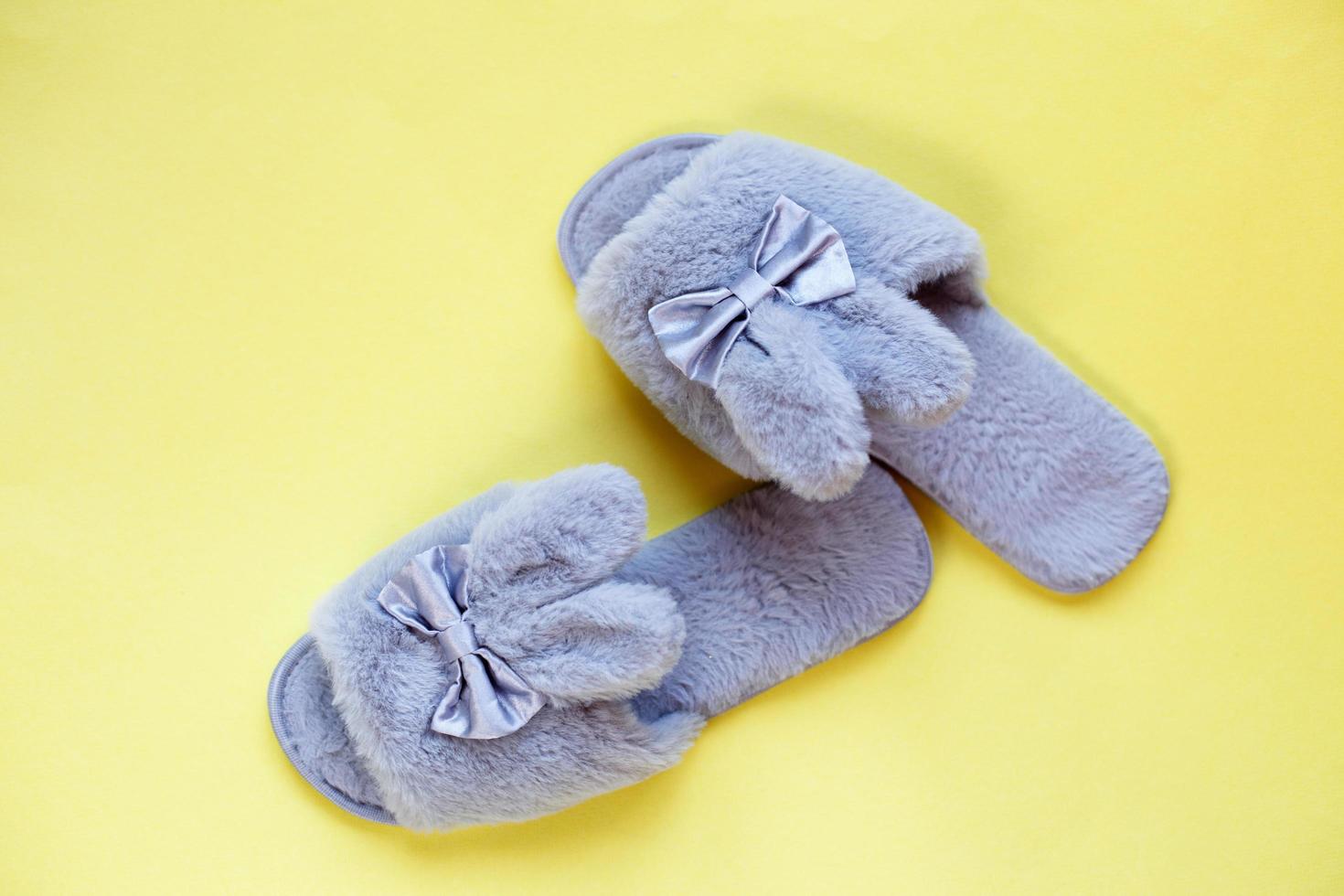 Pair of stylish soft slippers on yellow background, flat lay. copy space for text photo