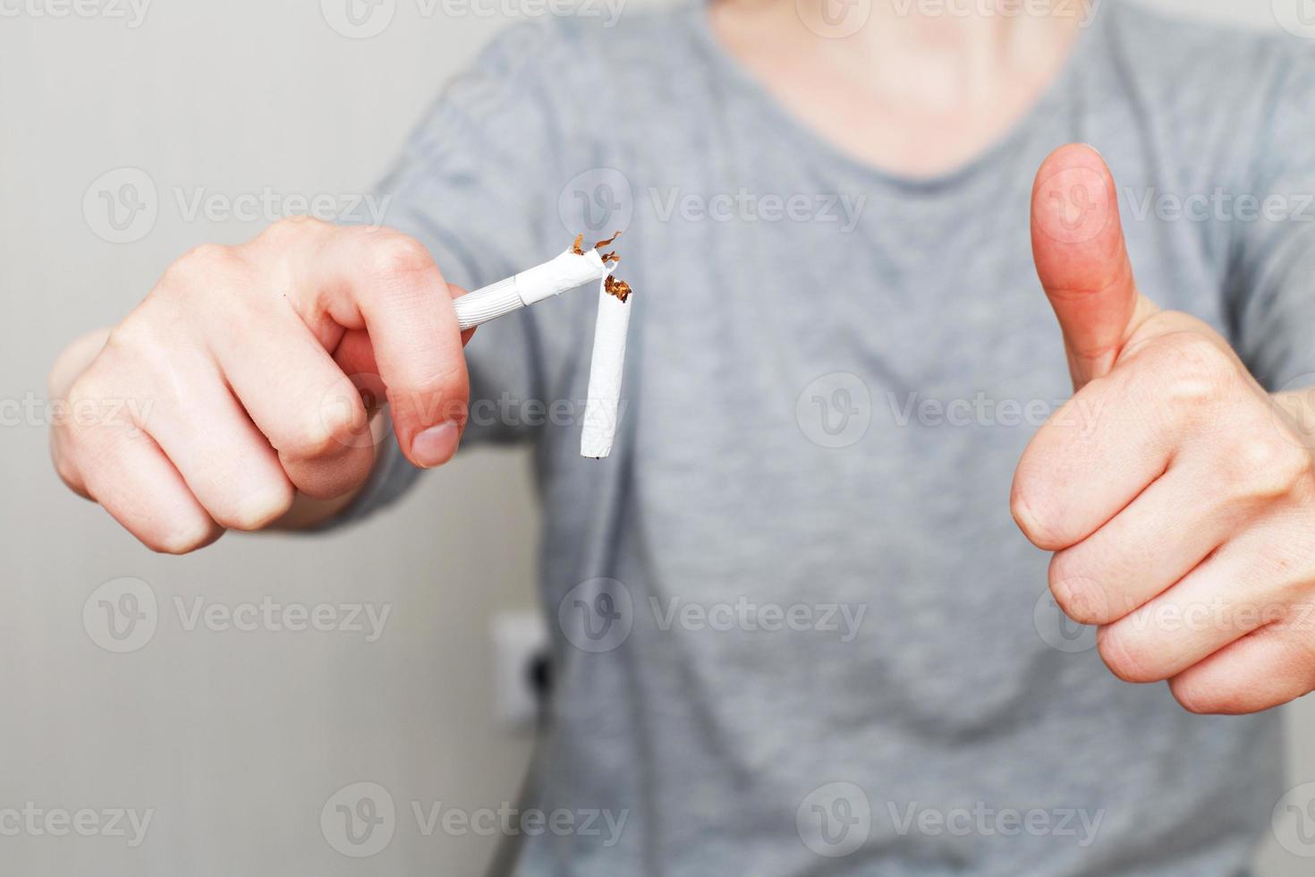 young woman holding broken cigarette in her hands close photo