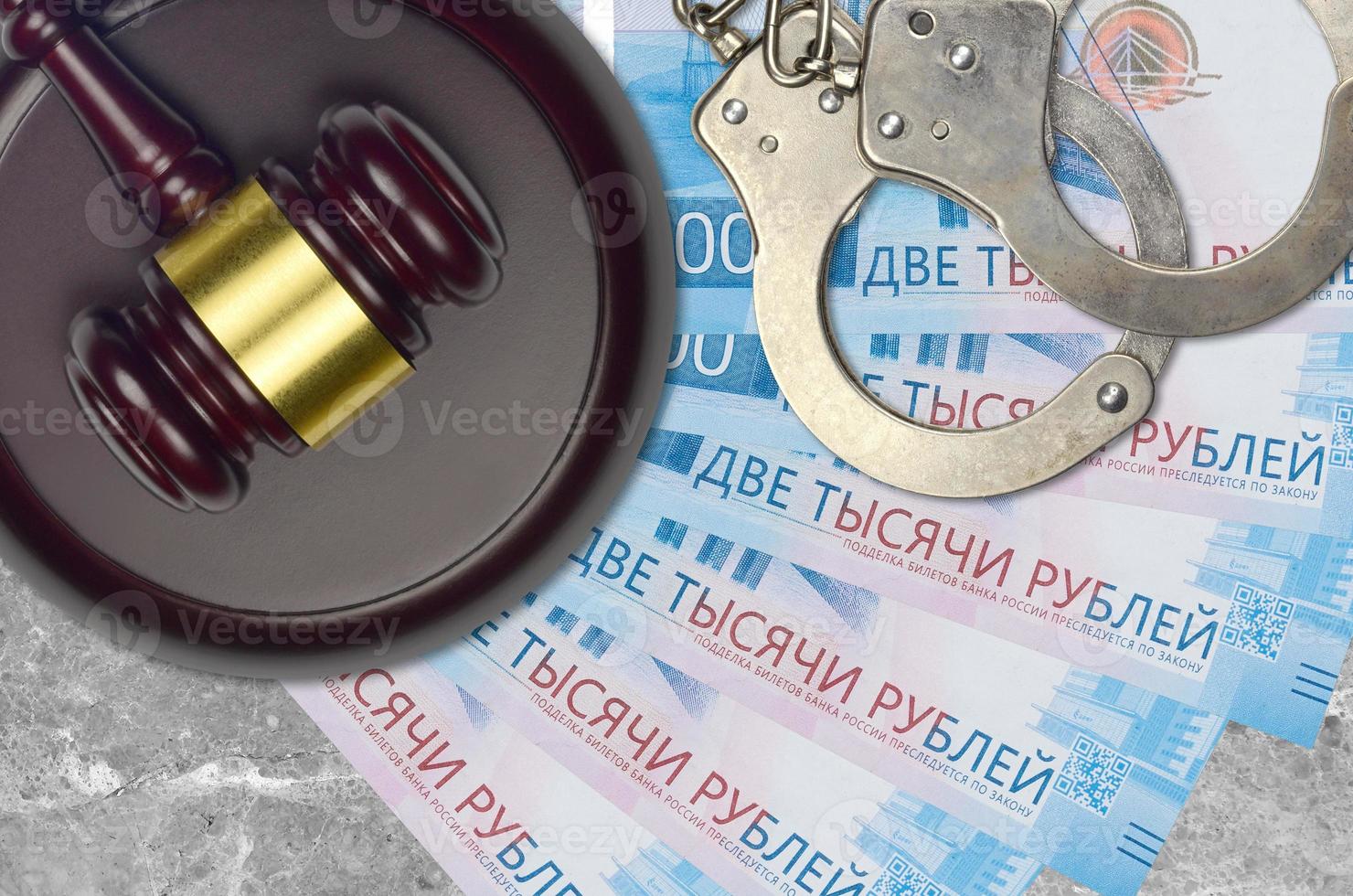 2000 russian rubles bills and judge hammer with police handcuffs on court desk. Concept of judicial trial or bribery. Tax avoidance photo