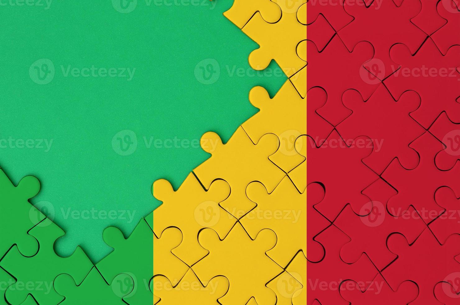 Mali flag is depicted on a completed jigsaw puzzle with free green copy space on the left side photo