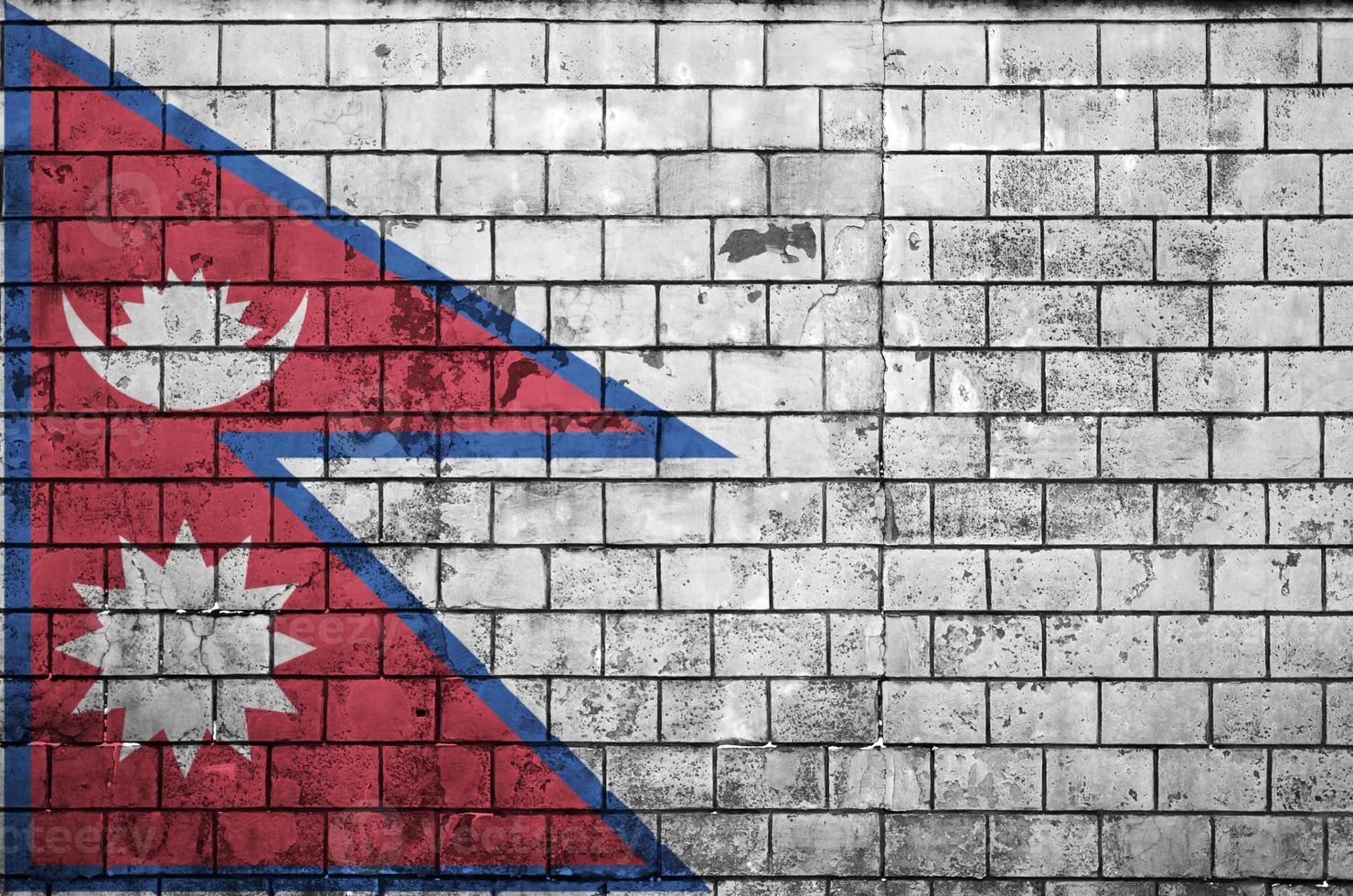 Nepal flag is painted onto an old brick wall photo