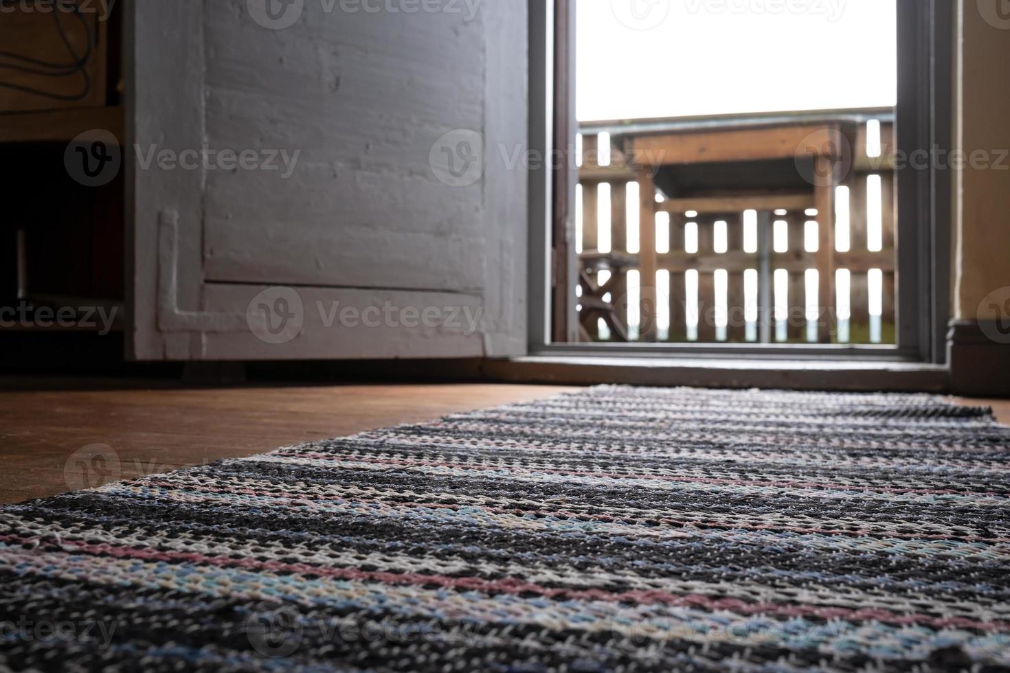 Open white door with access to the balcony, against a blurred background table. photo