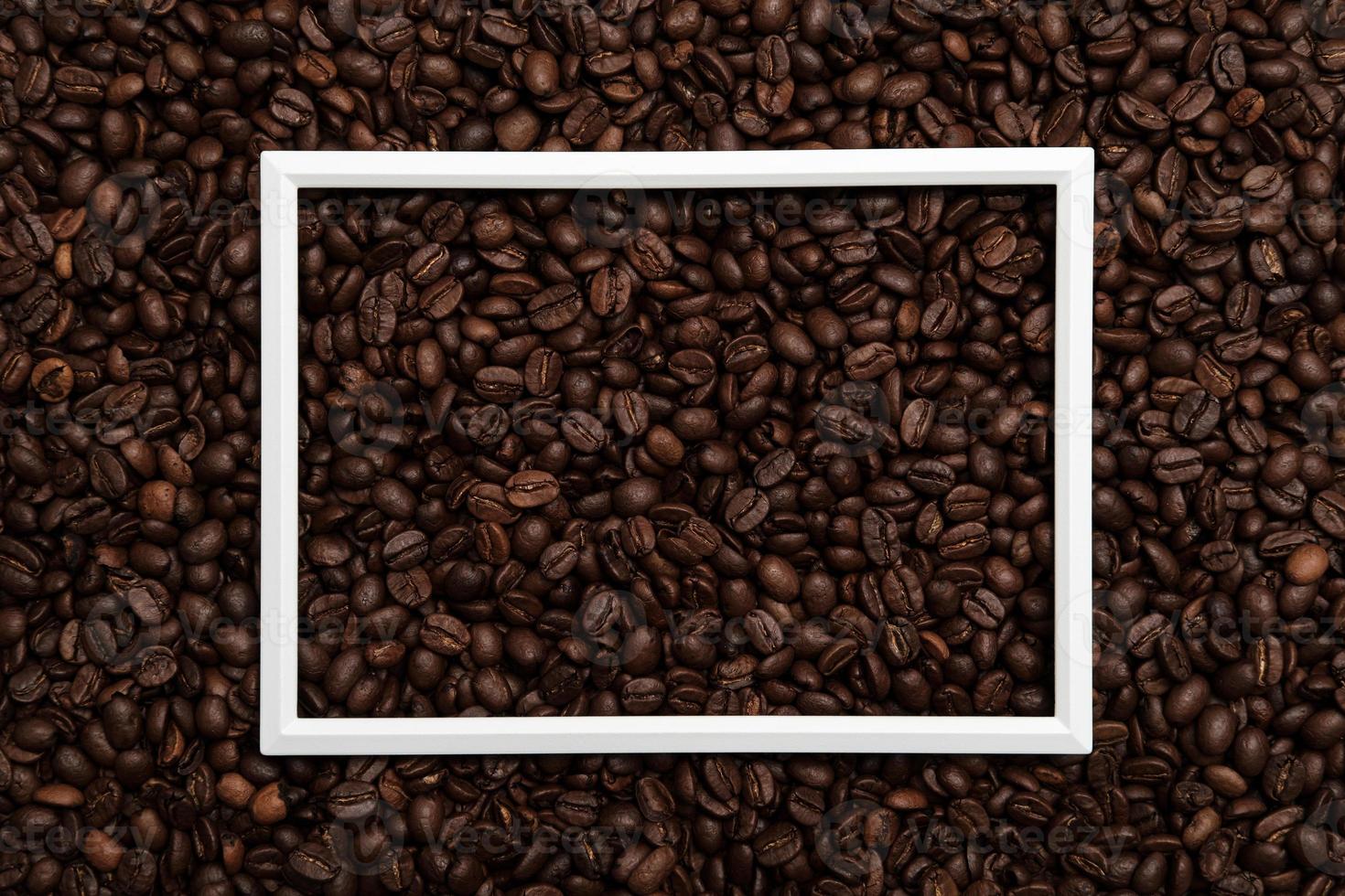 White frame on roasted coffee beans. Beautiful background. Copy space. Top view. photo