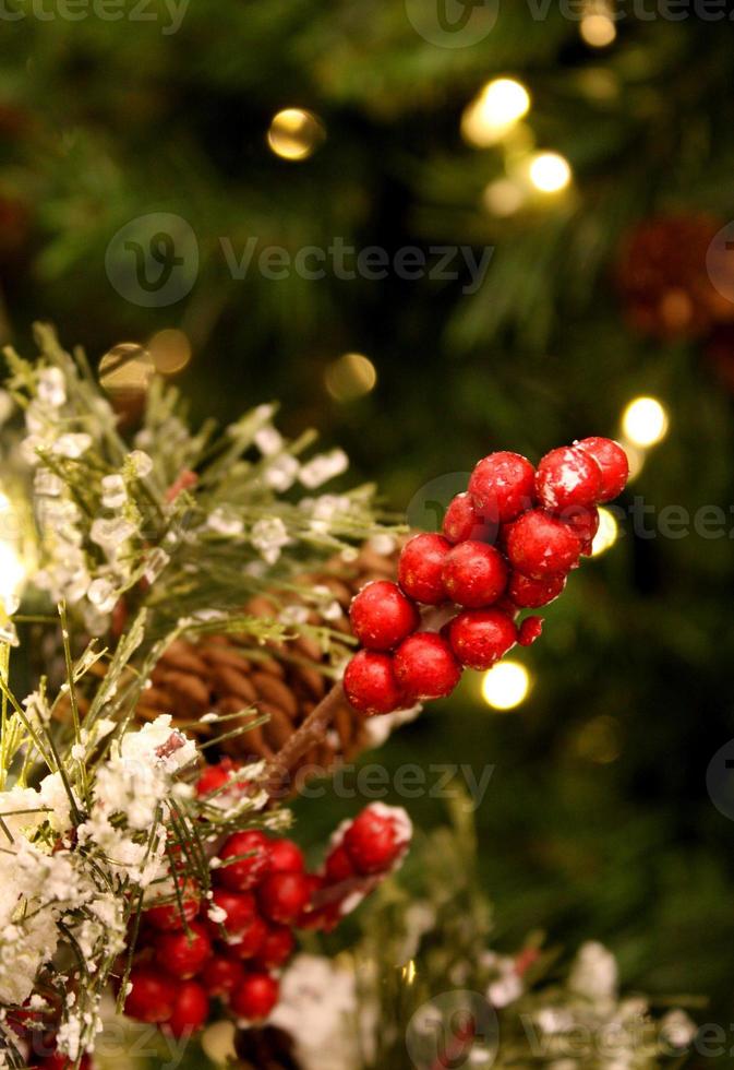 bayas rojas brillantes en un árbol de navidad flocado foto