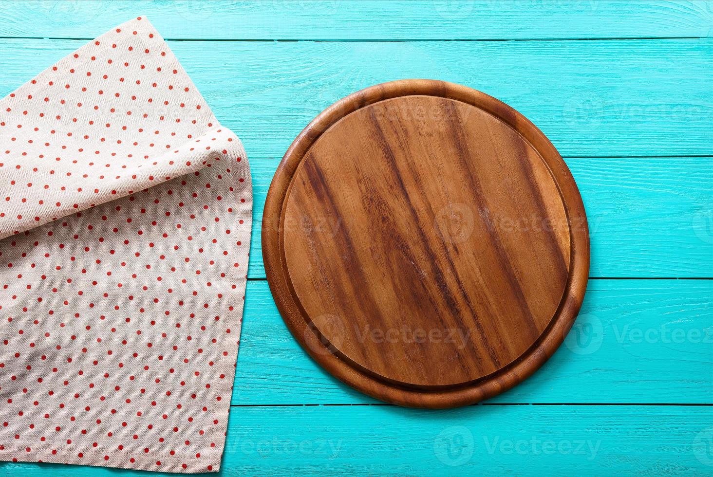 Frame of cutting board on polka dots tablecloth. Blue wooden background in the cafe. copy space photo