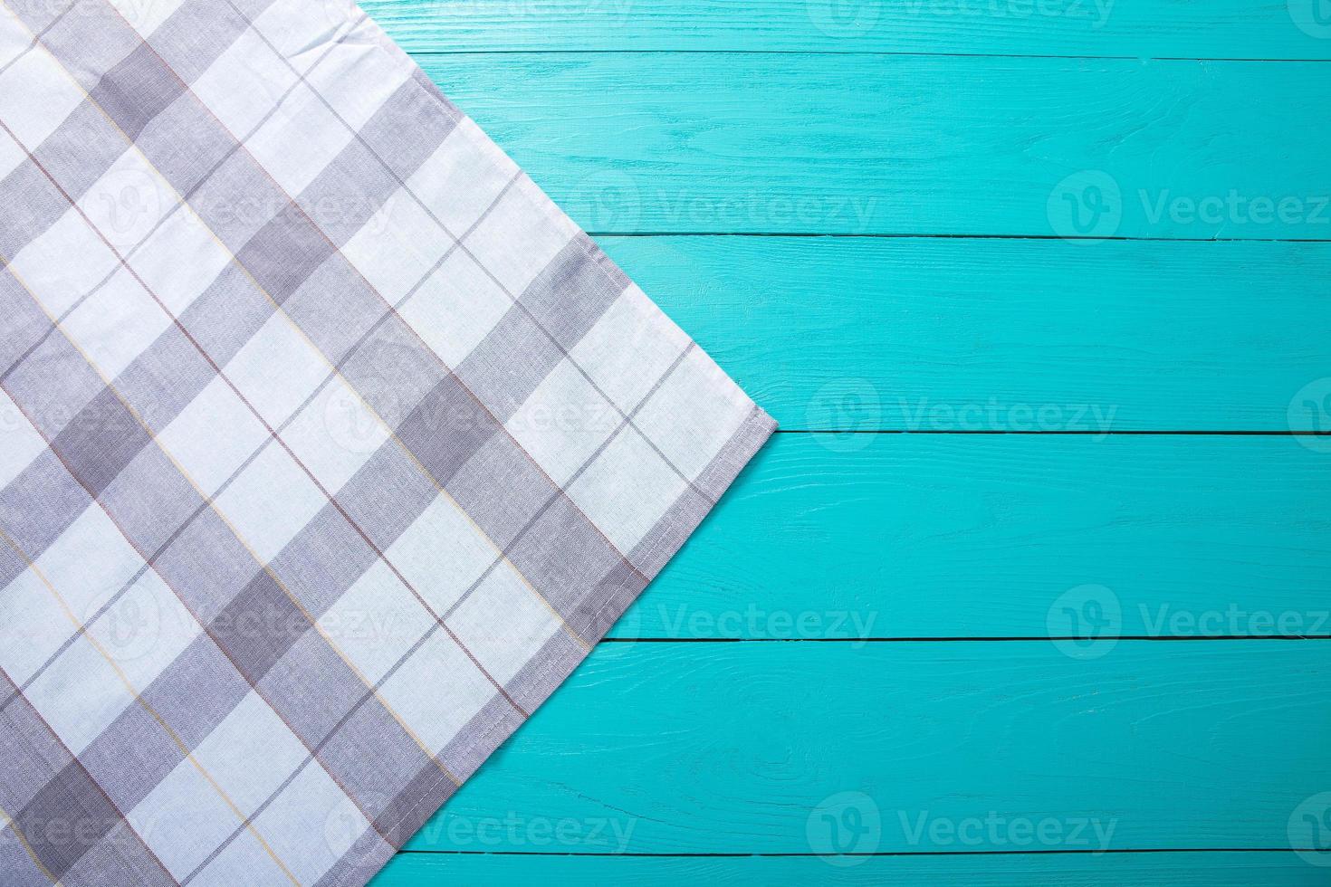 Grey plaid tablecloth on blue rustic wooden table, top view and copy space. Mock up and wood background. photo