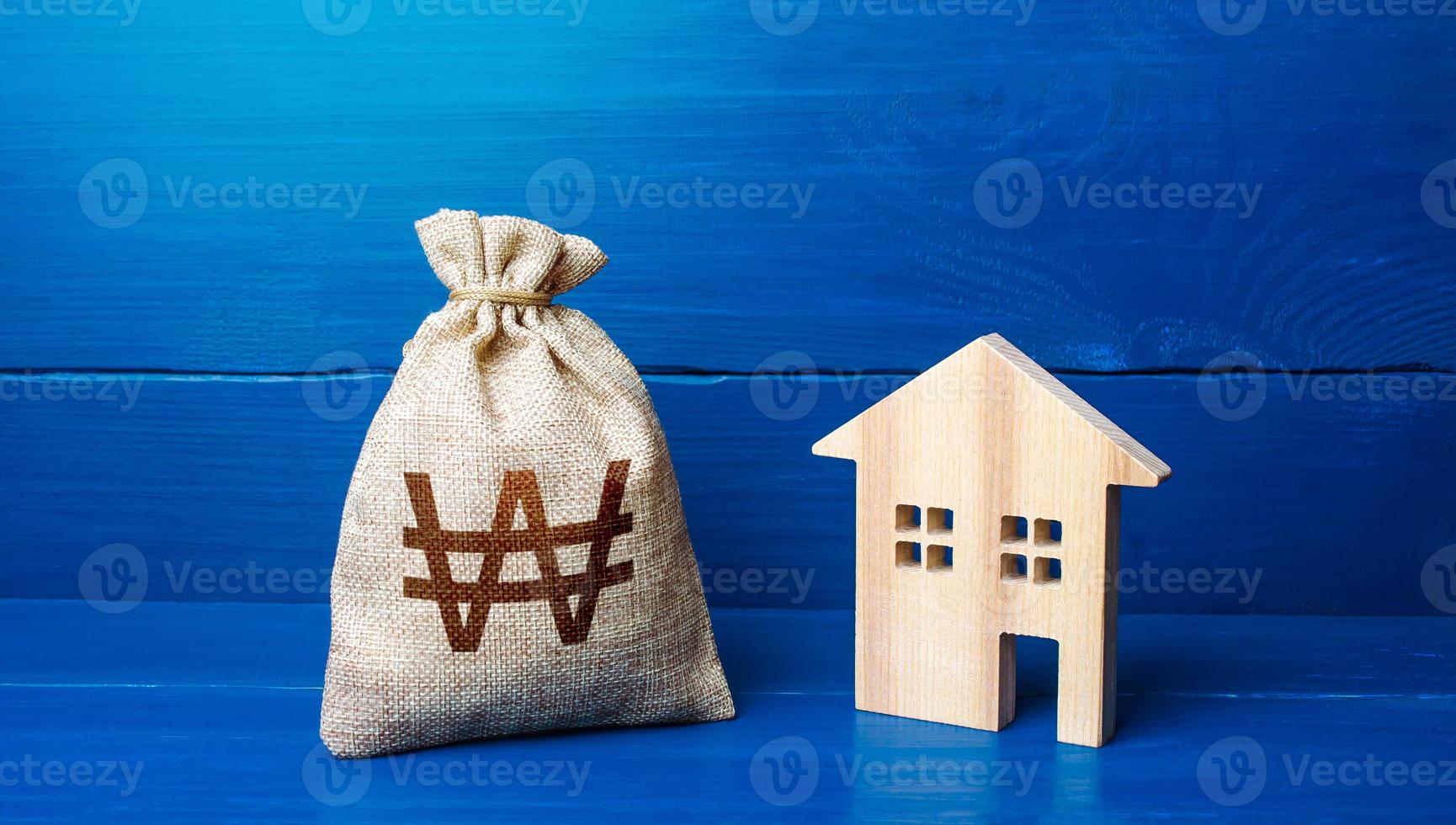 Figurine silhouette house and south korean won money bag. Taxes. Mortgage loan. Sale of housing. Proposal for a deal price. Buying and selling real estate. Maintenance, property improvement. photo