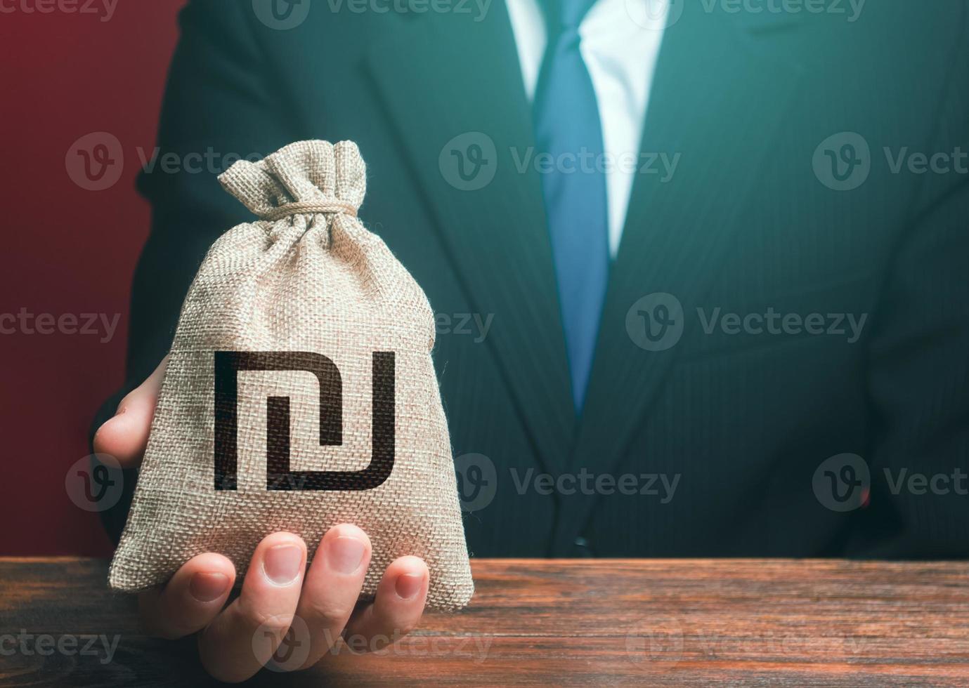Man gives a israeli shekel money bag. Loan issuance. Investments, financing Lobbying. Funding. Accounting, tax payment. Earnings and profits. Financial support, leasing. photo