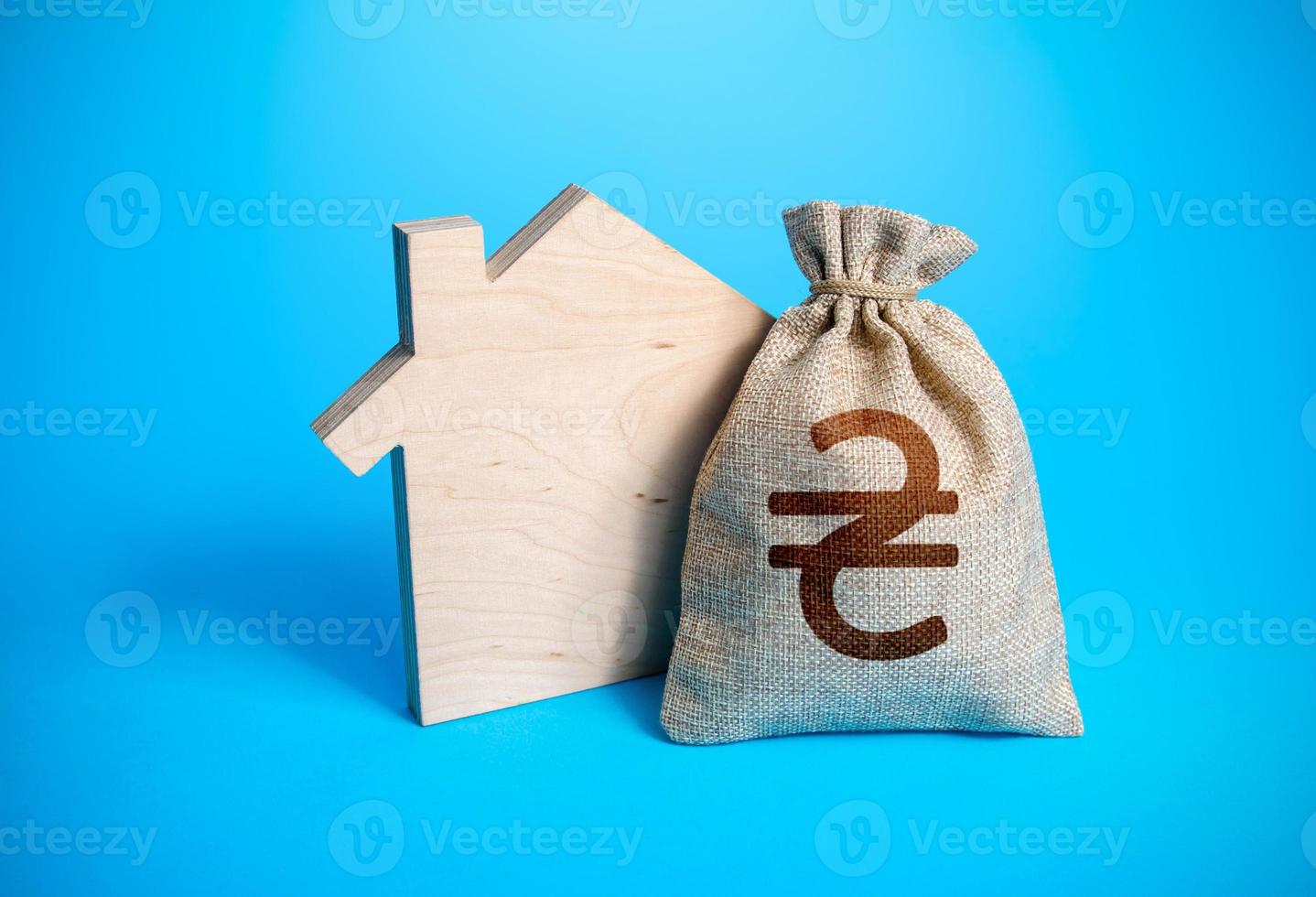 House silhouette and a ukrainian hryvnia money bag. Mortgage loan. Realtor services. House project development. Rental business. Property appraisal. Home purchase, investment in estate construction. photo