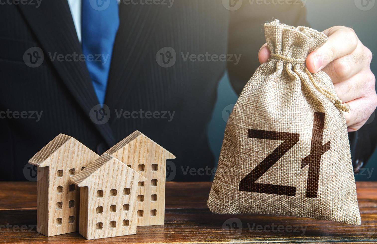 Polish zloty money bags and residential buildings figures. Taxes. Bank offer of mortgage loan. Rental business. Sale of housing. Municipal budget. Investments in real estate and construction industry. photo