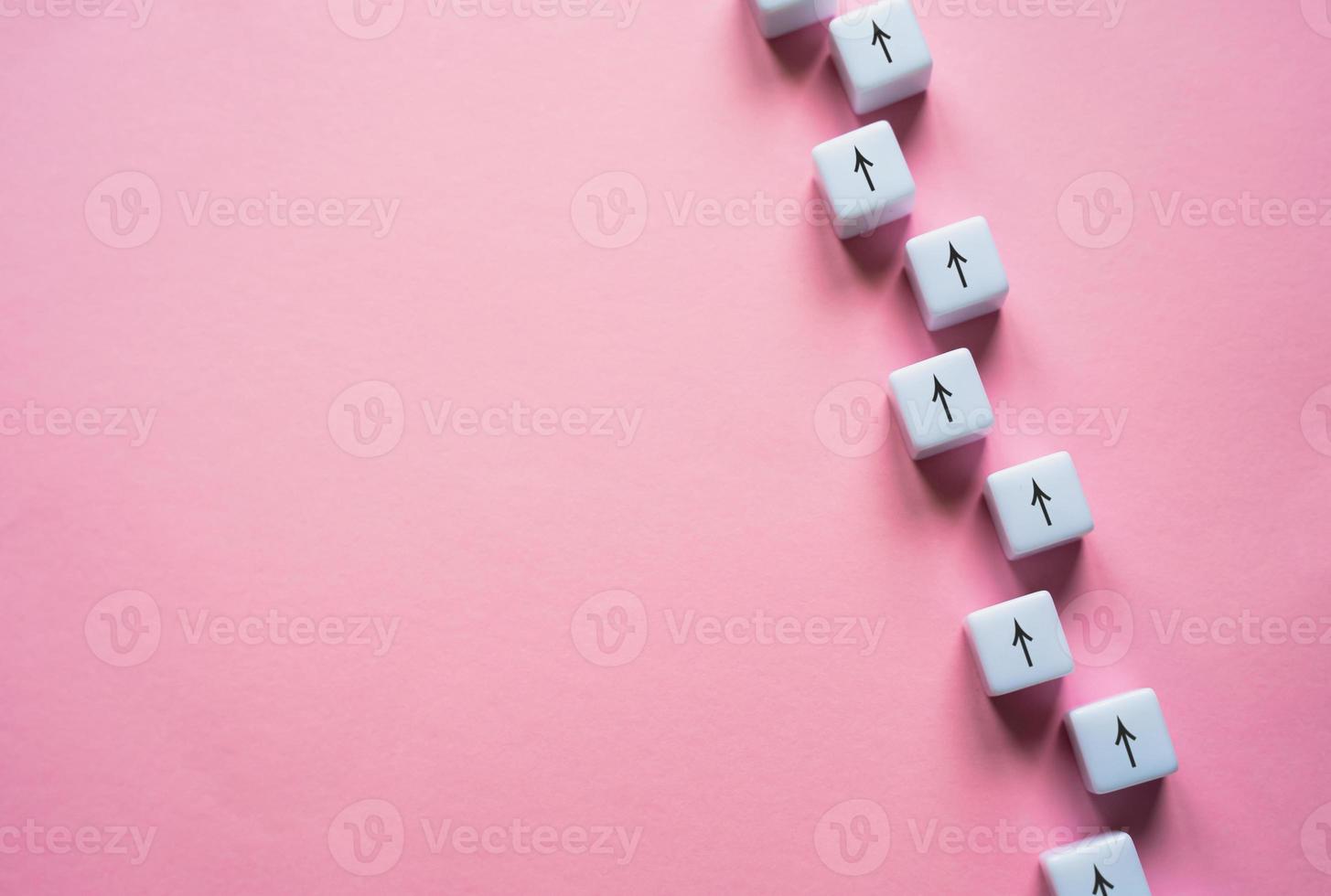 Chain of arrows blocks on a pink background. Concept of conformism, vertical of power. Consistency and focus. Unchanging course of development. Education and skill growth. Building a solid strategy. photo