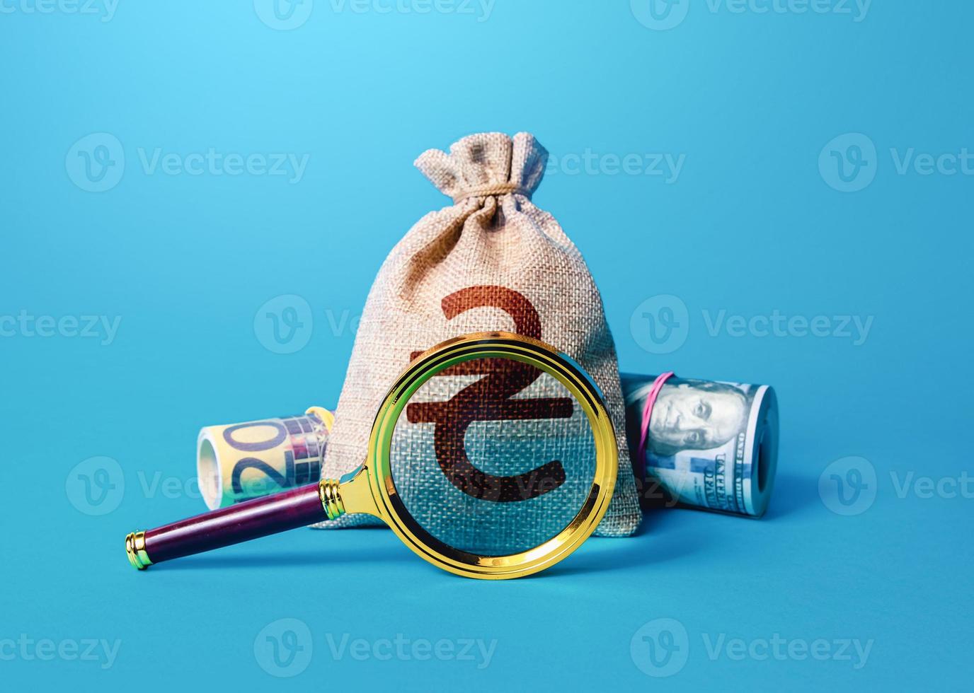 Ukrainian hryvnia money bag and magnifying glass. Anti money laundering, tax evasion. Deposit or loan terms and conditions. Find investment funds for business project. Investigating capital origins. photo